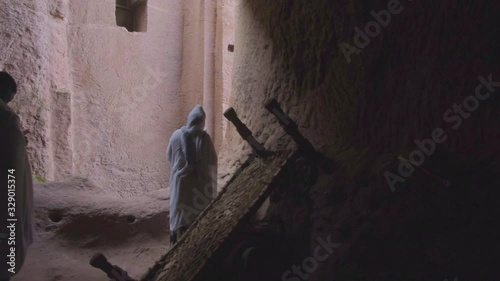 Camera track left to reveal Ethiopian pilgrims praying at Bet Gabriel Rufael rock-hewn church in Lalibela, Ethiopia photo