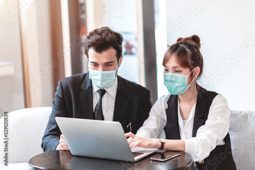 Businessman and Businesswoman Wearing Protective Mask for Protect from Air Pollution, Environmental Awareness and Coronavirus (COVID-19) Outbreak.They Working with Colleagues in an Office