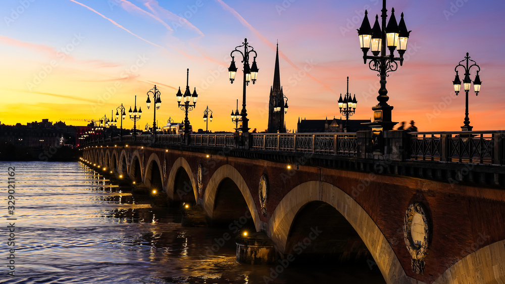 Pont de Pierre bridge in Bordeaux at sunset as the night sky scene