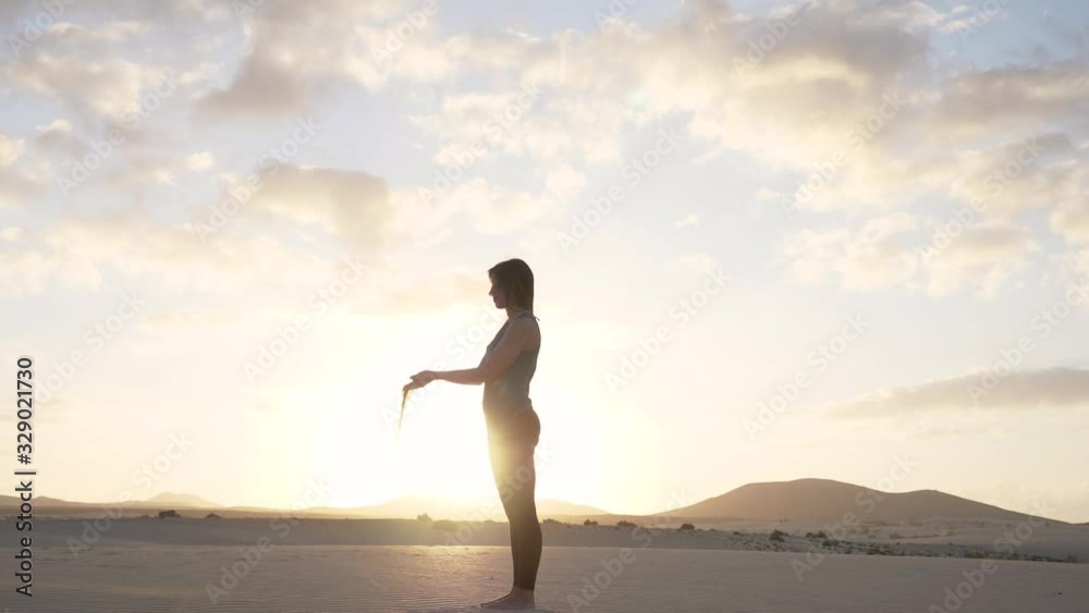 SLOW MOTION Young attractive woman releasing sand from hands. Sand flowing with wind in desert at sunset. Wellness and relaxation concept. SLOW MOTION Young attractive woman releasing sand from hands. Sand flowing with wind in desert at sunset. Wellness and relaxation concept.