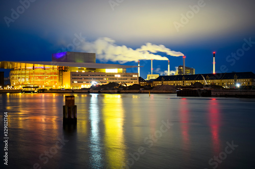Night view to Copenhagen Opera House Operaen and Amager Bakke factory smoke pipes in Copenhagen, Denmark. February 2020 photo