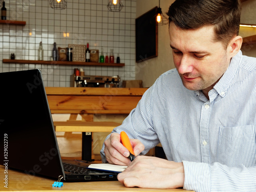 Fotografía Man in the cafe makes notates in the notepad.