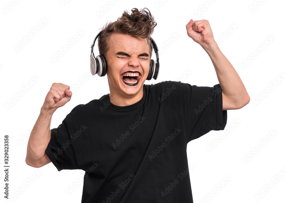 Rebellious happy teen boy with headphones, isolated on white background. Cheerful child listening to music and singing song. Emotional portrait of teenager in style of punk goth enjoying music. Rebellious happy teen boy with headphones, isolated on white background. Cheerful child listening to music and singing song. Emotional portrait of teenager in style of punk goth enjoying music.