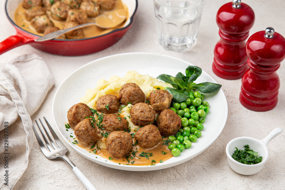 meatballs with mashed potato, cream sauce and green peas on white plate meatballs with mashed potato, cream sauce and green peas on white plate