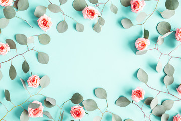 Flowers composition. Rose flowers and eucalyptus branches on blue background. Valentines day, mothers day, womens day concept. Flat lay, top view, copy space