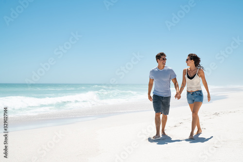 Young happy couple walking on beach