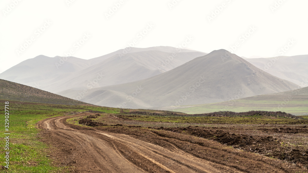 Fototapeta premium Winding dirt road in farm field