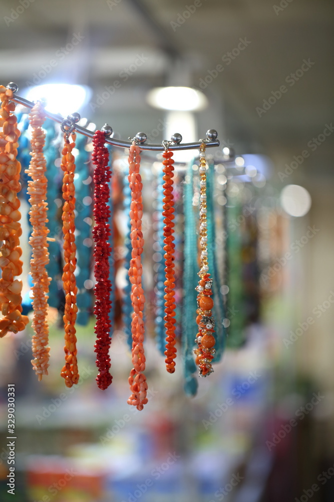 Necklaces from semiprecious stones in showcase of shop