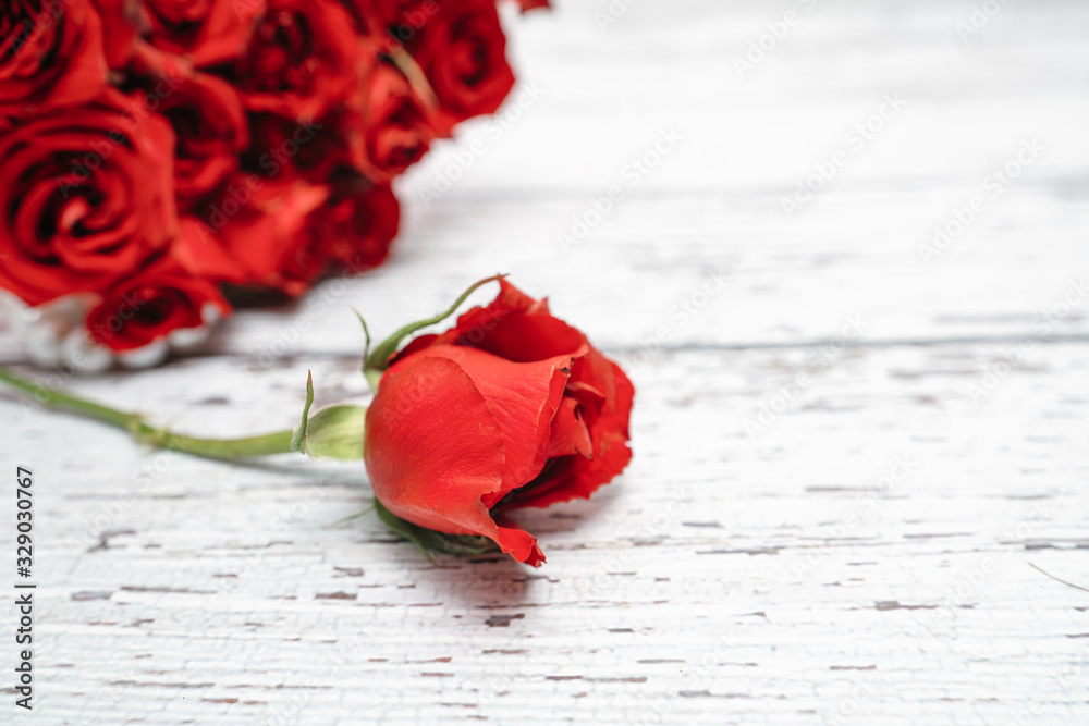 Φωτογραφία A bouquet of scarlet roses for Valentine's day ornaments concept with white wooden background