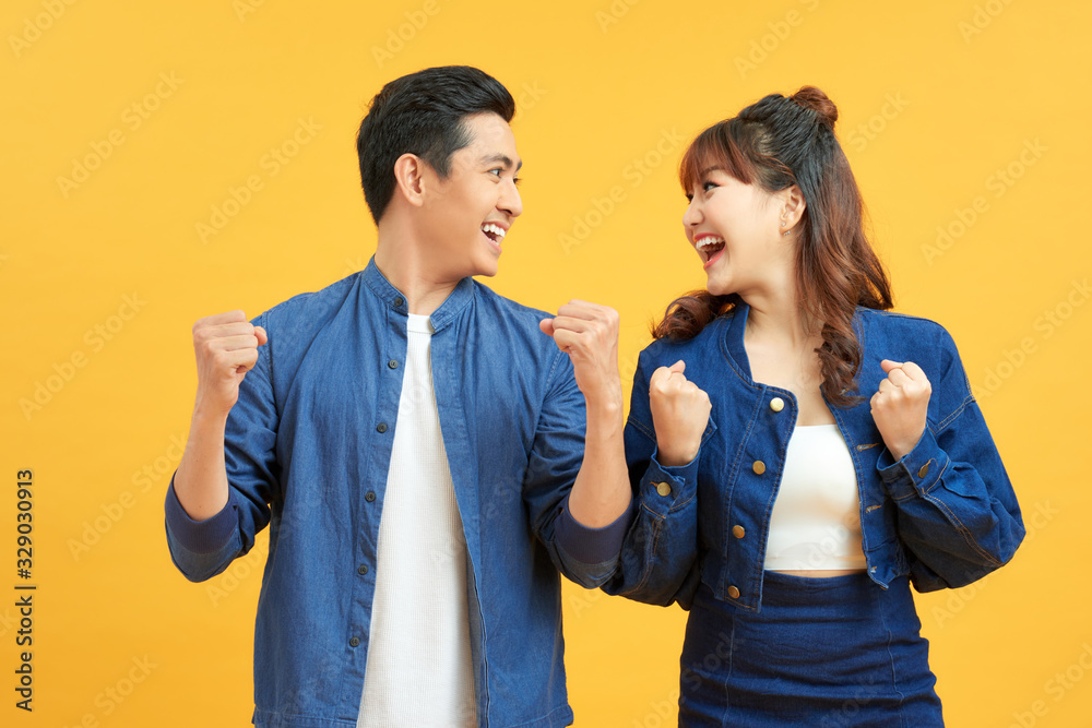 Thrilled man and woman with open mouth positive surprise isolated on yellow background Thrilled man and woman with open mouth positive surprise isolated on yellow background