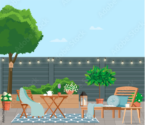 Back patio with garden furniture on a background of green plants.