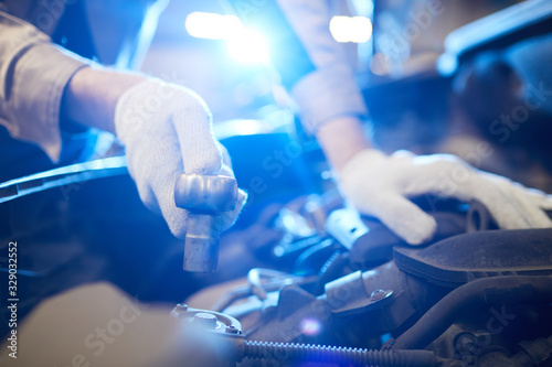 Horizontal close up shot of unrecognizable man's hands in white gloves repairing modern car engine, copy space