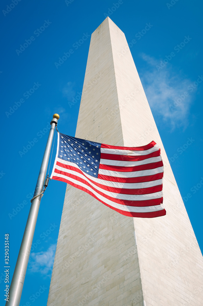 Φωτογραφία American flag flying outdoors in bright sun at the foot of the Washington Monume