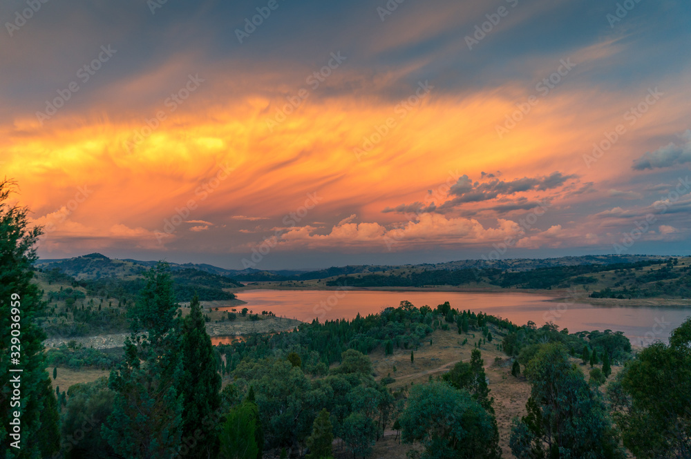 Aerial view of dramatic sunset over river valley with distant mountains