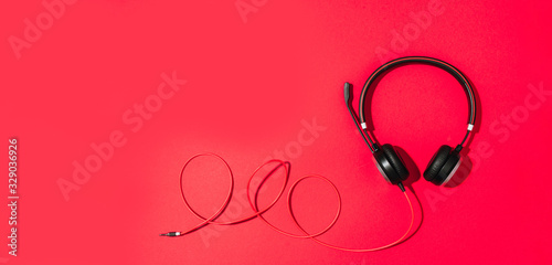 Music and sound concept. Style black headphones on red background. Top view. Copy space. Urban summer time. Banner © jchizhe