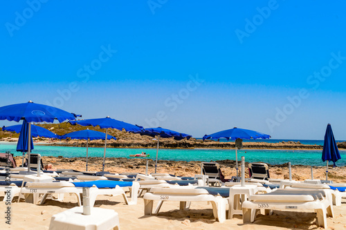 blue sunbeds and umbrellas on the famous cyprus beach nissi beach