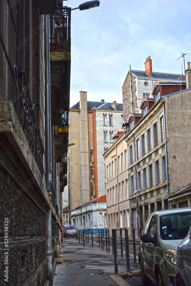 Saint-Etienne, France - January 27th 2020 : Old street in the city center, with ancient buildings, showing the steel industrial past of the place. There was mines here in the past.
