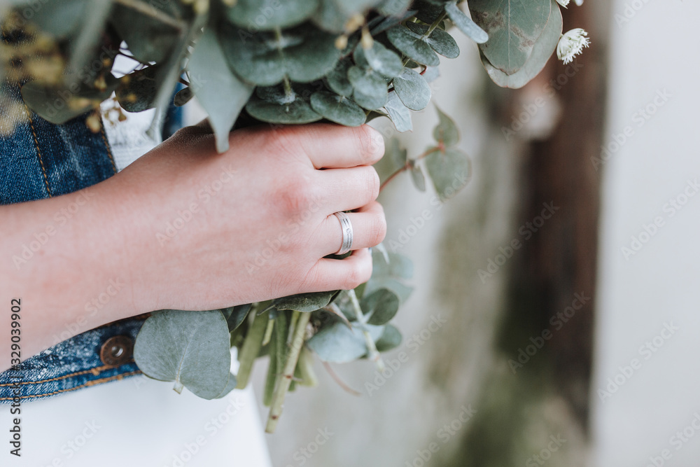 Ehering an einer Hand Braut mit Strauß