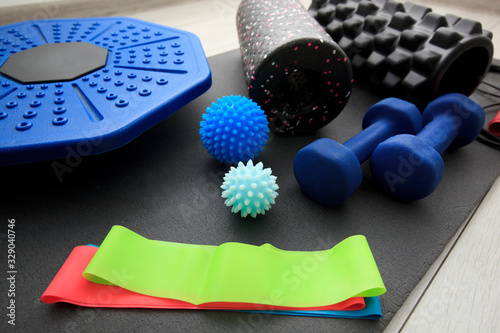 Fototapeta Naklejka Na Ścianę i Meble -  A lot of different fitness and sport accessories and equipment on the wooden floor at home