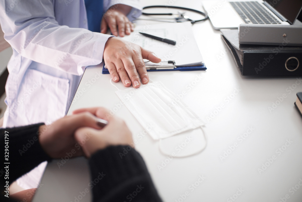 Female medicine doctor working on table with consulting patient, giving mask to patient for prevent viruses Female medicine doctor working on table with consulting patient, giving mask to patient for prevent viruses