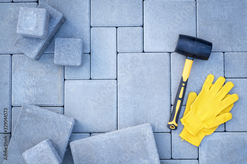 Paving stones paving background. Installing tools on foreground