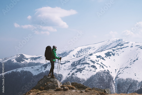Amazing landscape with snowy mountains range and hiker with backpack on a foreground