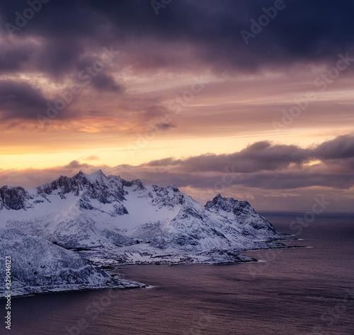 Mountains and sky during sunset. Senja island, Norway. Clouds on the sky during sundown. Nature background.