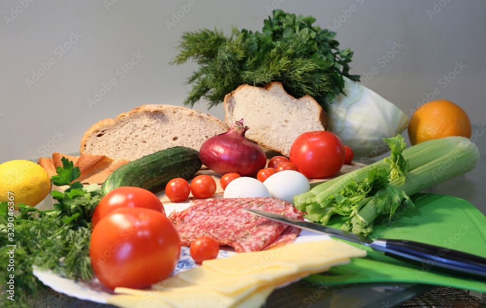 Still life from breakfast food from fresh vegetables, butter, oranges, bread, sausage, cheese side view Still life from breakfast food from fresh vegetables, butter, oranges, bread, sausage, cheese side view
