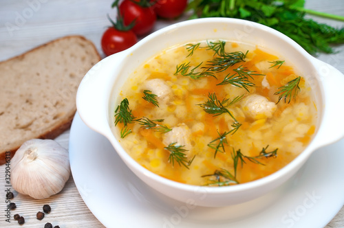 Chicken soup with meatballs and pasta on the table