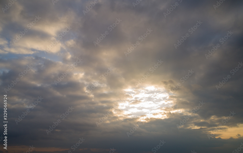 Dark cloudy sky with red reflections at sunset.