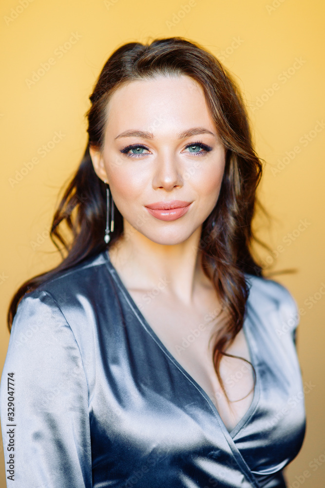  Portraits of a girl in an expensive evening dress. Beautiful girl in the Studio on a yellow background.