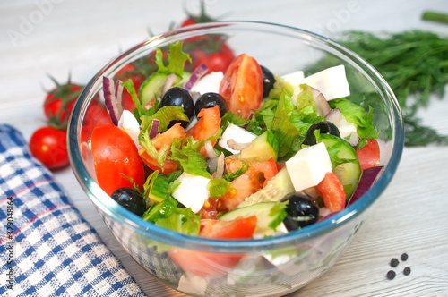 Greek salad with tomatoes, cucumbers and feta cheese with olives on the table