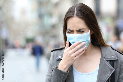 Sick woman with protective mask coughing on street