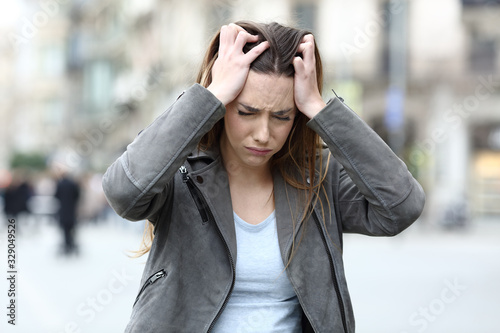 Konstfotografi Stressed girl grabbing head complaining on city street