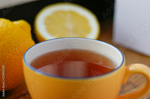 cup of tea and sliced lemon on a wooden table