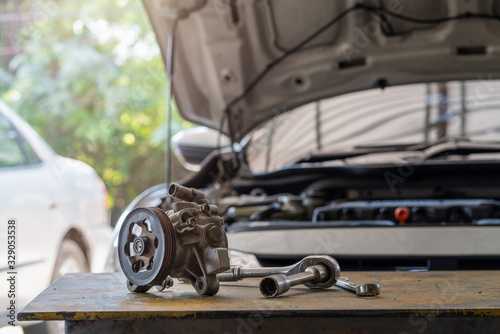 Power steering gear pump of the car with wrench tools on working table in repair and maintenacne garage