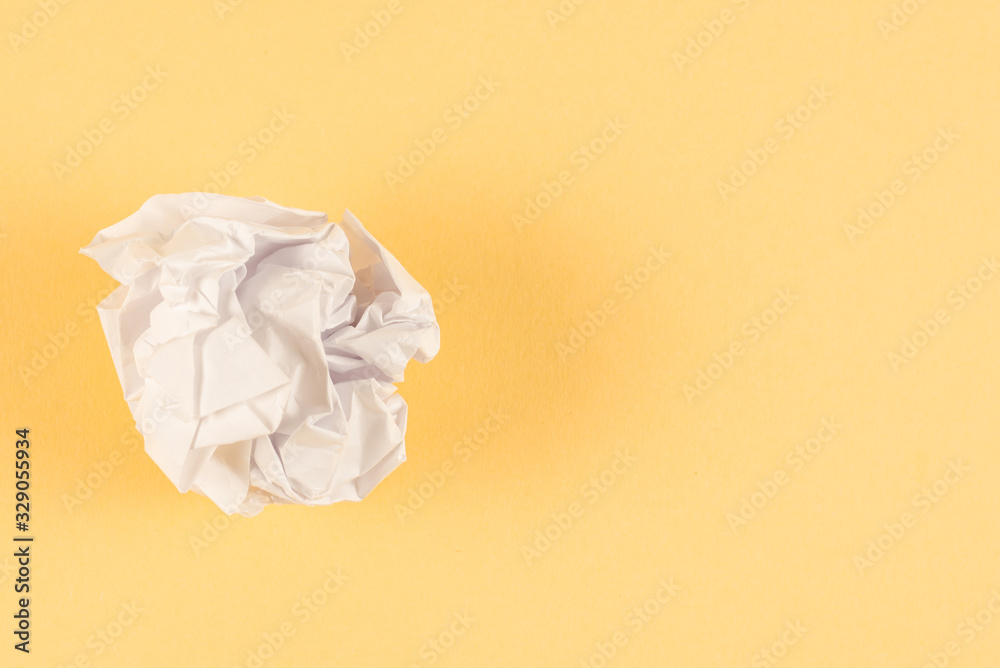 Crumpled white paper on a beige background.