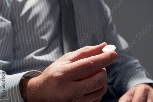 businessman with a pill  hands close view - concept of difficulties  depression  problems  health and stress  risk of modern business