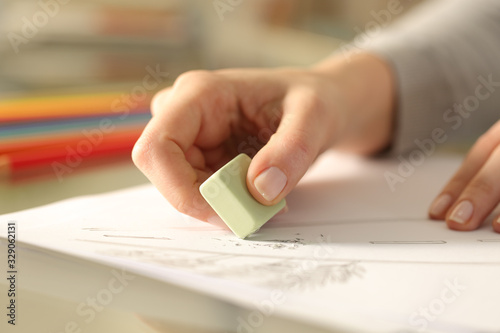Woman using rubber erasing drawing on a desk photo