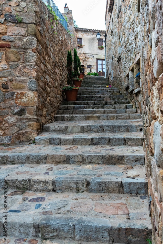 Tossa de Mar, Spain, August 2018. Narrow street in the old fortress as a staircase to the fortress wall.