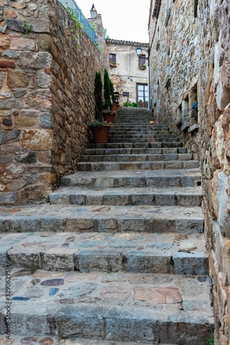 Tossa de Mar, Spain, August 2018. Narrow street in the old fortress as a staircase to the fortress wall. © Dmirii