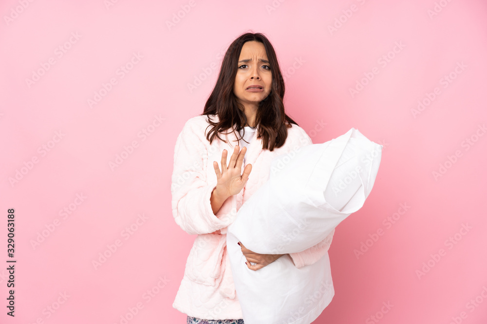 Young woman in pajamas isolated on pink background nervous stretching hands to the front Young woman in pajamas isolated on pink background nervous stretching hands to the front