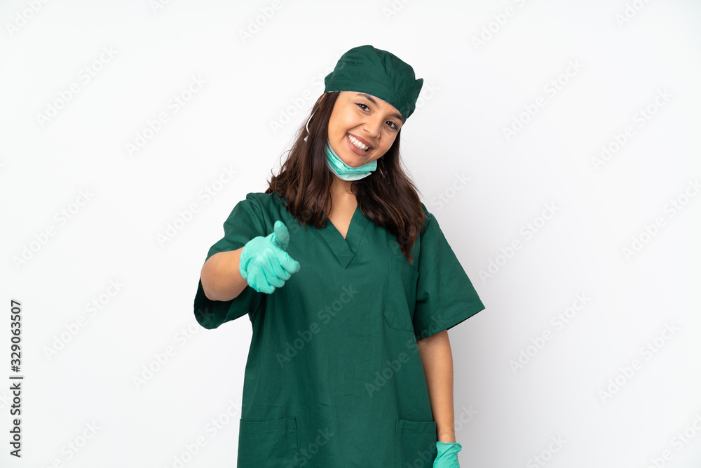 Surgeon woman in green uniform isolated on white background with thumbs up because something good has happened Surgeon woman in green uniform isolated on white background with thumbs up because something good has happened