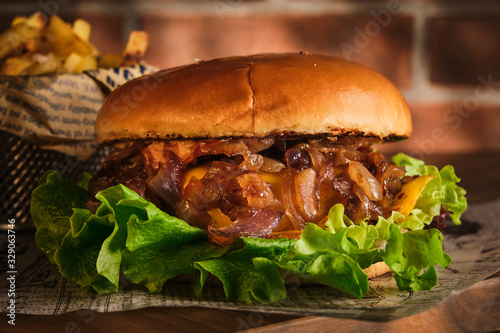 Quadro su tela Burger with beef and caramelized onions on a wooden board