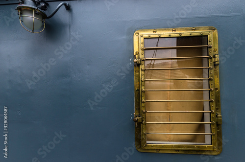 Bronze porthole of the ship on a gray background