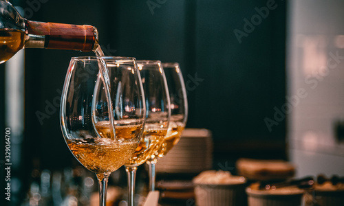 Photo bartender pouring white wine into a glass in cafe or bar