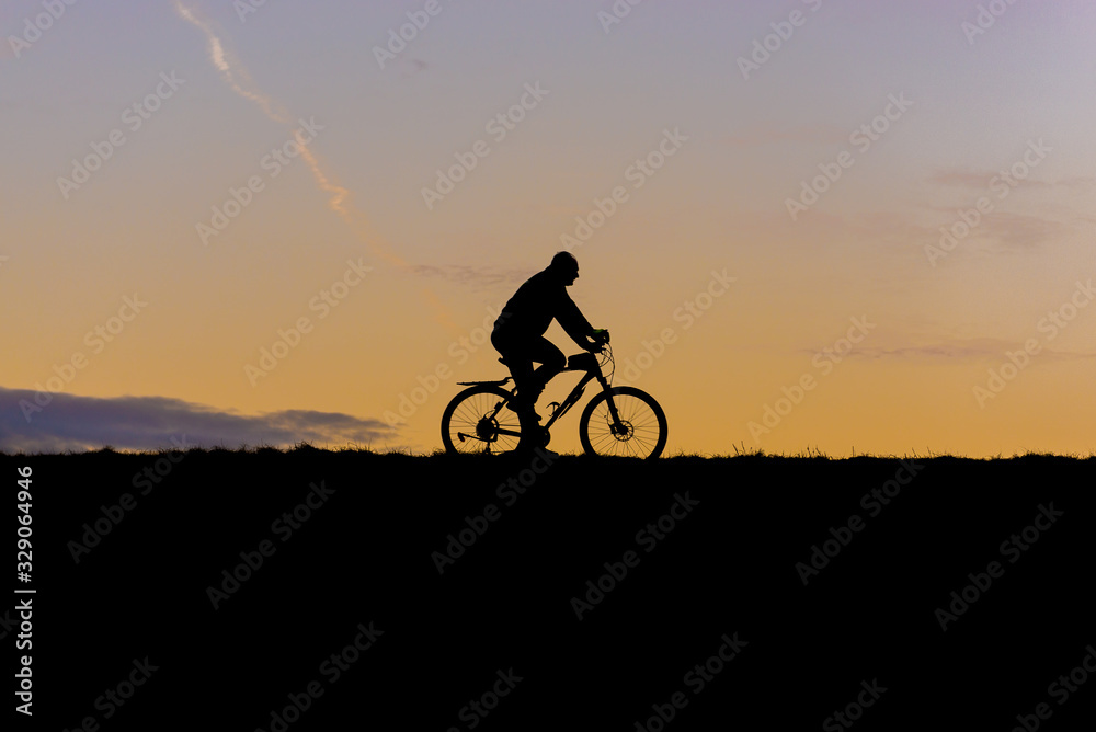 Obraz premium Man rides bike on a Vistula River stopbank in Warsaw, Poland