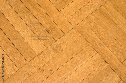 Wooden flooring is light brown. Parquet board laid diagonally