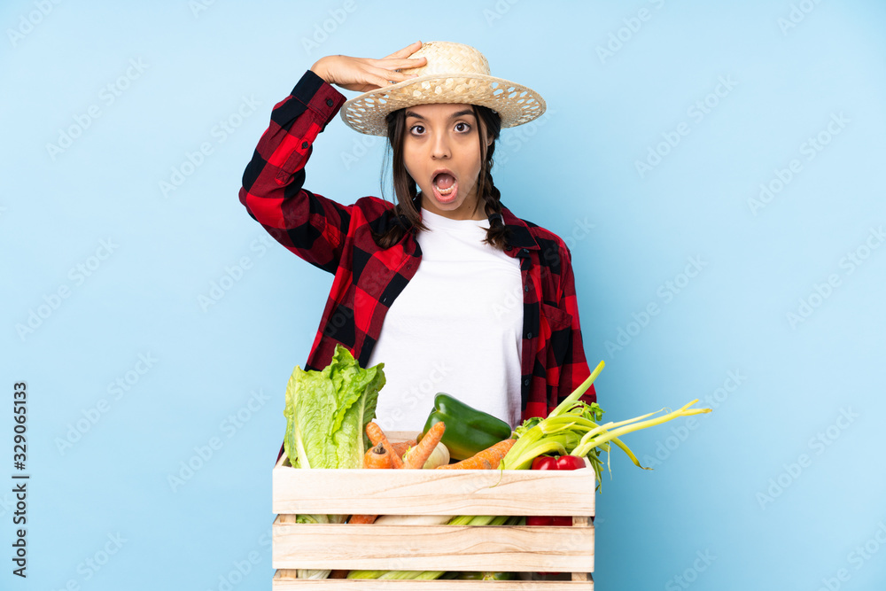 Young farmer Woman holding fresh vegetables in a wooden basket has just realized something and has intending the solution