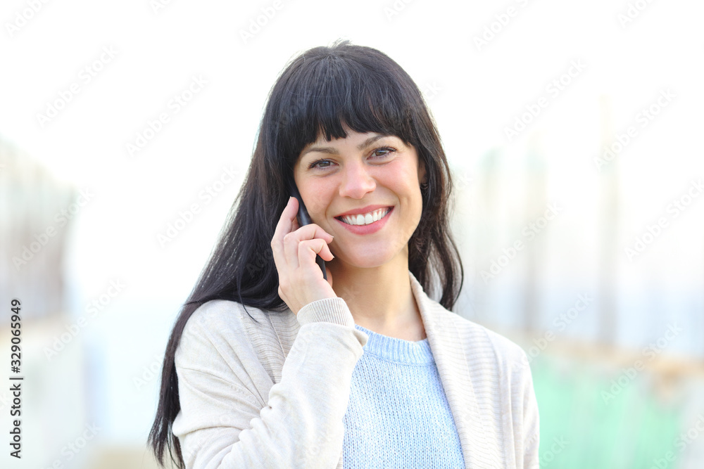 Happy woman talking on phone looking at camera Happy woman talking on phone looking at camera